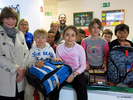 Gruppenbild mit fröhlichen Kindern und neuen Schulranzen im Klassenraum